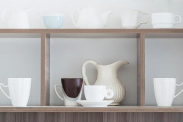 Fototapeta na wymiar white kitchenware on wooden shelf