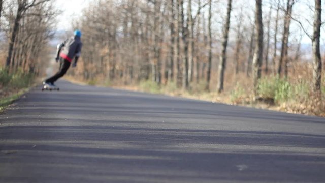 long boarder ride the road through the forest