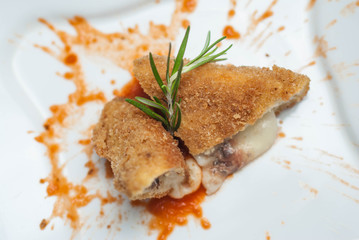 Pane Fish Meat. Fried Fish Meat with tomatoes Sauce on White Plate. Close up Food. Vertical image.