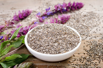 Chia seed healthy superfood with flower over wooden table