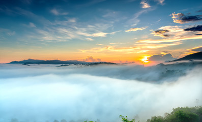 Dawn on plateau in morning with colorful sky, while sun rising from horizon shines down to small village covered with fog shrouded  landscape so beautiful idyllic countryside Dalat plateau, Vietnam