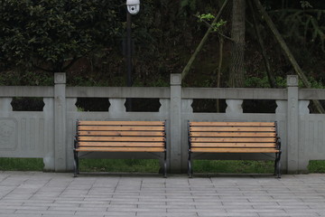 Naklejka premium Wood Benches along the foot path for taking a rest in the Park