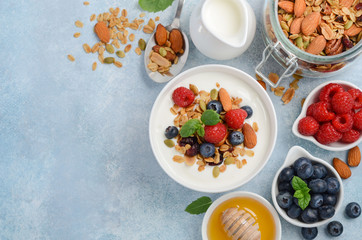 Homemade granola with yogurt and fresh berries, healthy breakfast concept, top view, copy space.