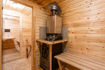 Obraz na płótnie Canvas interior of sauna. rural mobile wooden bath in the form of a barrel in a pine forest