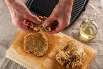 man sculpts hands dough for flat bread on the background of the grill
