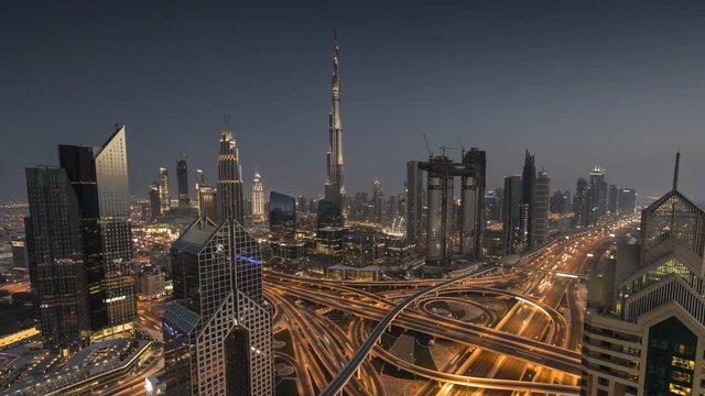 Day to night time lapse of modern downtown of Dubai. Burj Khalifa on background. Moving blur cars on Sheikh Zayed road.