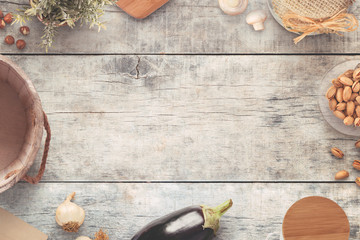 Old vintage style kitchen table with cooking ingredients. Copy space in the middle. Flat lay. Wooden background.