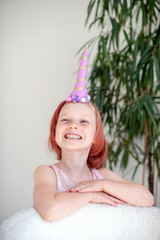 The smiling girl in the unicorn costume