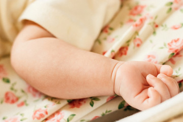 Baby hand on her bed.