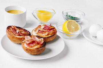 Ingredients for eggs Benedict bun with bacon, lemon, sauce, coriander