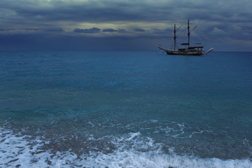 wooden Boat in sea against a cloudy skyline.