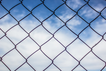 metal fence concept on blue sky with clouds background and empty space for your text