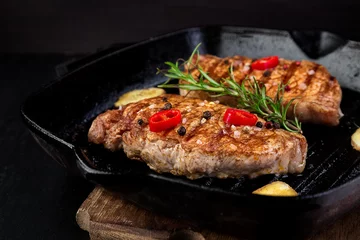 Tuinposter Grilled pork steak in grill pan © bondarillia