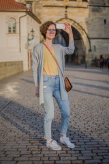 Obraz na płótnie Canvas A tourist woman walks along the Charles Bridge in Prague in the summer. Prague, Czech Republic