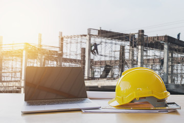 safety helmet and computer laptop on table in concstruction site