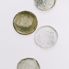 Hand made plates on white background. Flat lay, top view minimal pottery concept.