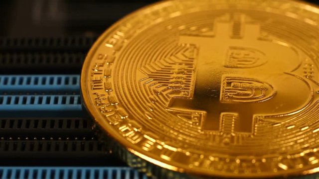 Golden Bitcoin Coins On Computer Circuit Board. Extreme Close Up