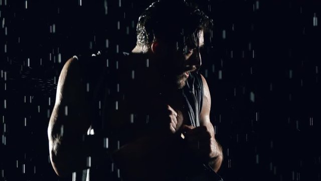 Athletic man shadow boxing in the rain.