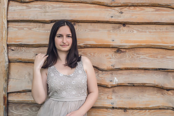 Girl in gray dress of wooden background. 