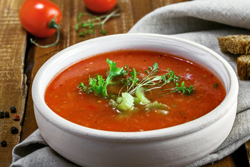 Gazpacho in a bowl, ingredients and bread. Classic Spanish cuisine vegetarian soup.