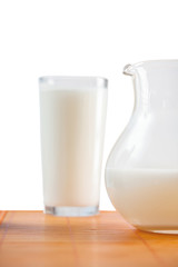 jug and glass of milk on table isolated