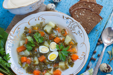 Plate with sorrel soup, bread and sour cream
