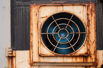 spinning fan on a rusty wall