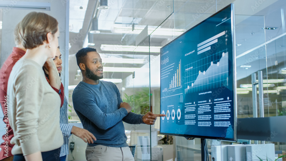 Poster diverse team of young professionals in conference room have discussion about statistics and graphs s