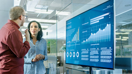 Male and Female Business Workers in Conference Room Have Discussion about Statistics and Graphs...