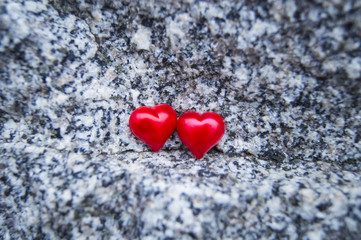 Fototapeta premium two red hearts on a beautiful stone background