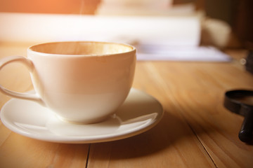 cup of hot coffee with foam and smoke on table in the morning. copyspace for your text