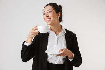 Portrait of a smiling young businesswoman drinking tea