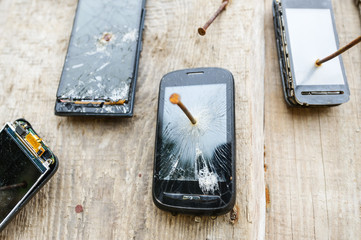 Obsolete mobile phones is nailed to a wooden fence