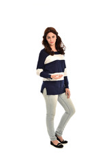 full length portrait of girl wearing striped blue and white jumper and jeans. standing pose on white studio background