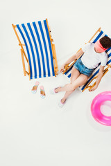 overhead view of woman resting in beach chair isolated on white, summer vacation concept