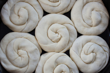 Raw twisted dough with stuffing rises in the roaster. Traditional moldavian food called platzinda
