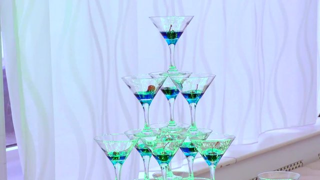Pyramid of champagne Glasses on the background of curtains. Accessories for a fun alcoholic party. 