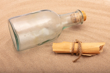 Wrapped message beside an old bottle on the sand of a beach