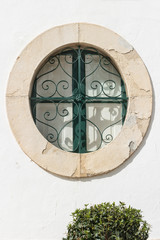 Round window on the background of a white wall. Close-up