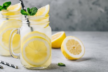 Homemade refreshing summer lemonade drink with lemon slices and ice in mason jars