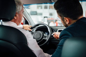 Aged man buy car with dealer.