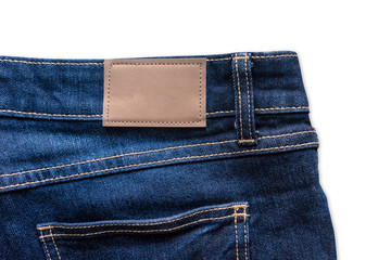 Back of blue jeans with leather jeans label sewed on blue jeans. Isolated on white background with...
