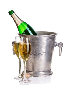 Champagne bottle in ice bucket with glasses of champagne.