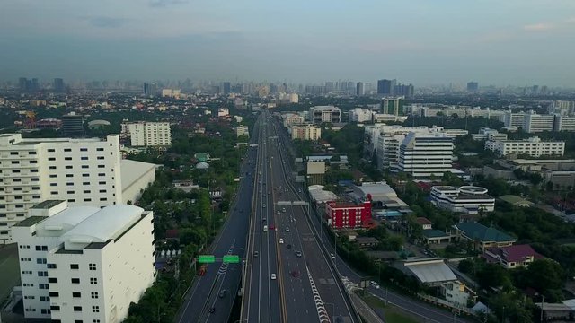 4K. Aerial view of highway road interchange with busy urban traffic speeding on the road. Junction network of transportation in Bangkok, Thailand. taken by drone