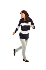 full length portrait of girl wearing striped blue and white jumper and jeans. standing pose on white studio background