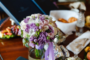Bouquet of flowers in vase on the background of snacks on the table. Beautiful fresh flowers on the wedding table
