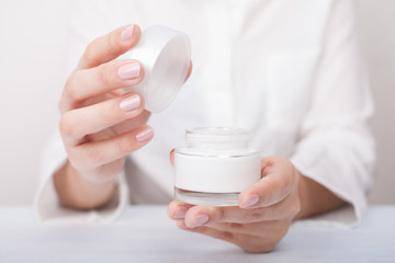Fototapeta na wymiar Closeup shot of woman hands applying moisturizing hand cream