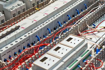A series of modular magnetic contactors and a range of power circuit breakers. Between the rows of contactors and switches and devices, perforated cable channels. They laid the electrical wire.