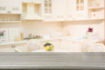 Blurred background. Empty wooden tabletop and defocused modern kitchen.