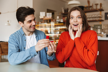 Cheerful young man proposing to a woman